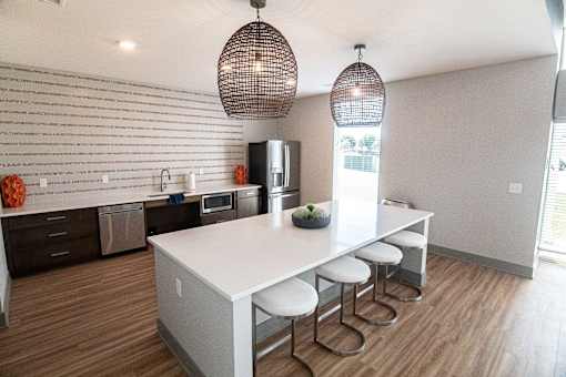 a kitchen with a white counter top and a dining table at Centennial Crossing, Waukee, Iowa