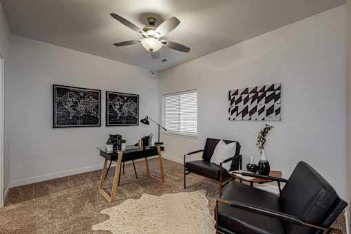 a living room with two black chairs and a ceiling fan at Centennial Crossing, Waukee, 50263