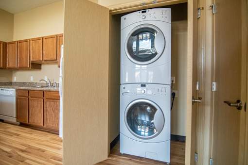 A white washing machine and dryer in a home laundry room.at Cottages at Johnston Commons, Johnston, IA 50131  