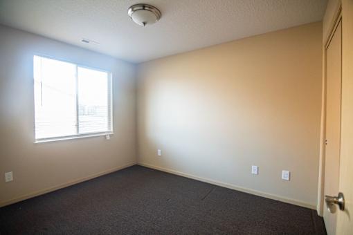A room with a window and a door.at Cottages at Johnston Commons, Johnston, IA 50131  