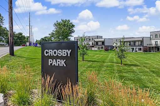 A sign that says Crosby Park in front of some houses.