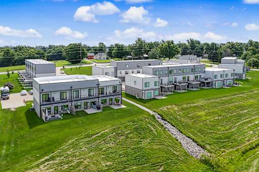 A large building complex with multiple structures and a green lawn in front.