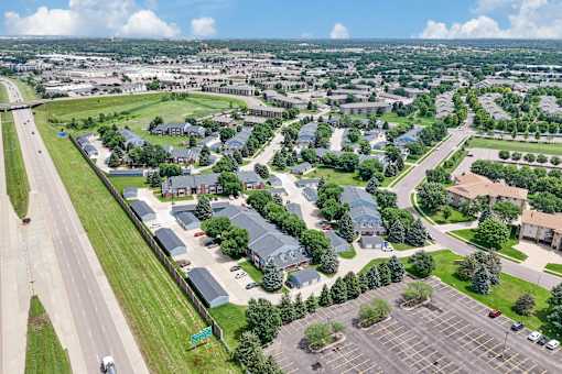 A bird's eye view of a suburban area with a parking lot in the foreground.