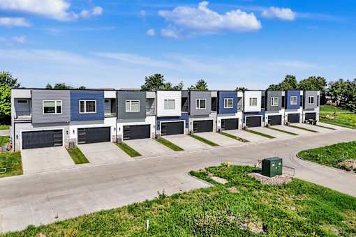 A row of modern houses with garages are lined up in a row.