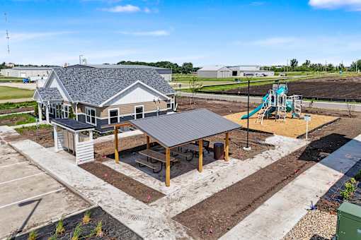 A playground with a slide and a building in the background.