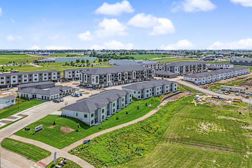 A large building complex with a green lawn in front.