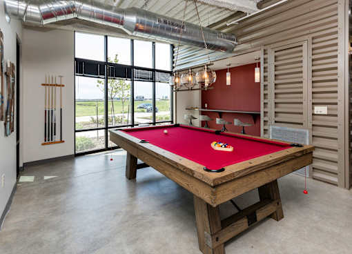 A pool table in a room with a view of the outside. at Eagle View Lofts, Des Moines, IA, 50309