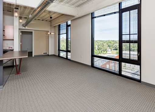 A large room with a table and chairs and a view of the outside. at Eagle View Lofts, Des Moines, Iowa