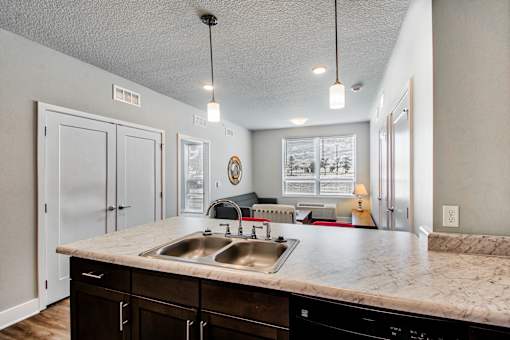 A kitchen with a marble countertop and a sink.
