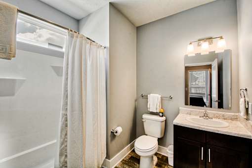A bathroom with a toilet, sink, and shower.