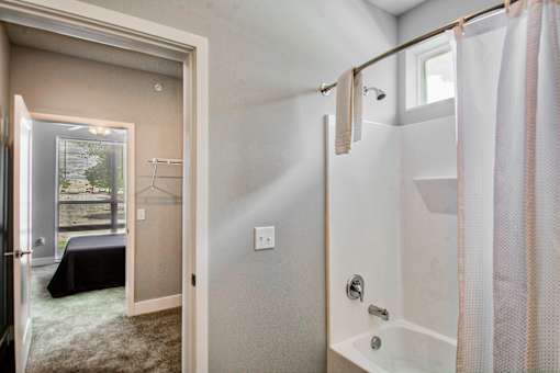 A bathroom with a shower and a window.