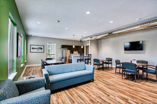 A living room with a blue couch and wooden floors.