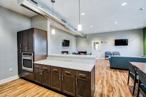 A modern kitchen with wooden floors and stainless steel appliances.