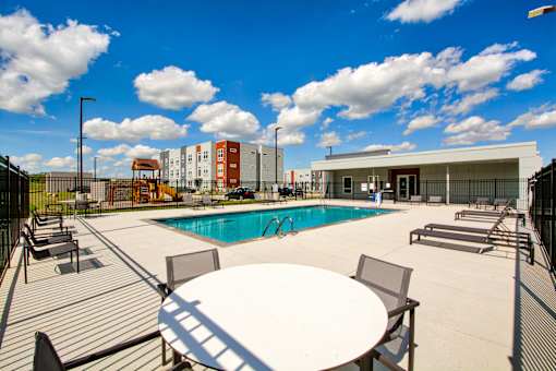 A pool area with a table and chairs.