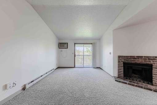 A room with a fireplace and a window with a view of a balcony.