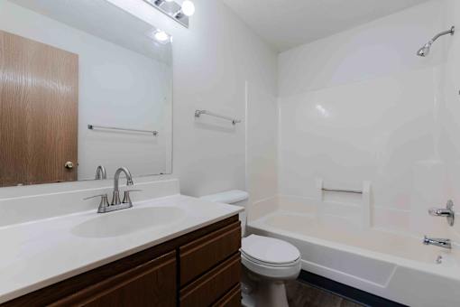 A white bathroom with a toilet, sink, and bathtub.