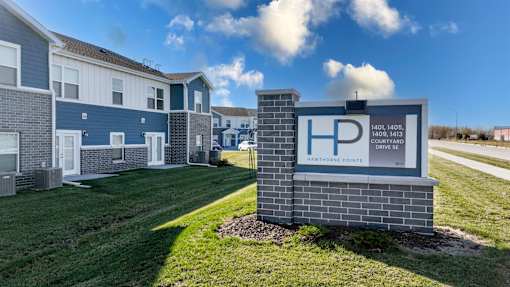 A sign for a housing development called Hamthorne Pointe stands in front of a building.