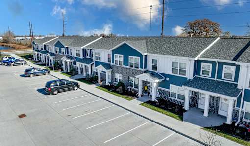 A parking lot in front of a blue and white building.
