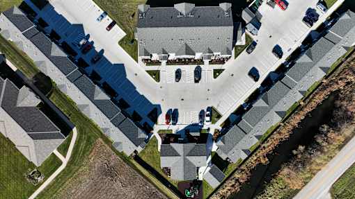 A bird's eye view of a residential area with houses and cars.