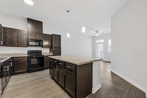 A modern kitchen with dark wood cabinets and a central island.