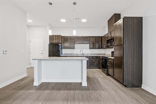 A modern kitchen with dark wood cabinets and stainless steel appliances.