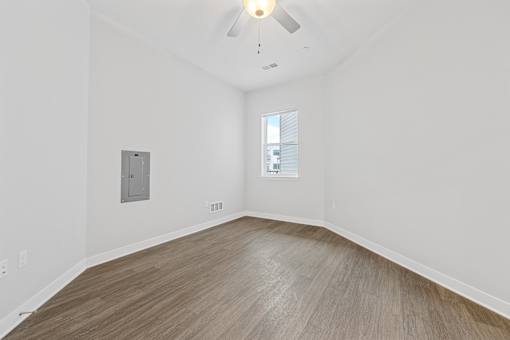 A room with a wooden floor and a ceiling fan.