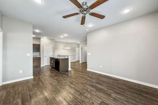 A spacious room with a ceiling fan and wooden flooring at The Barclay Apartments, Altoona, 50009