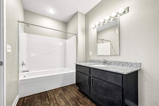 a bathroom with a sink and a shower and a mirror at The Barclay Apartments, Altoona, 50009