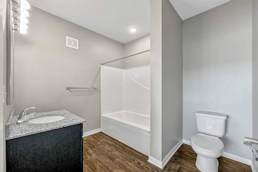 a bathroom with a toilet and a shower and a sink at The Barclay Apartments, Altoona, IOWA