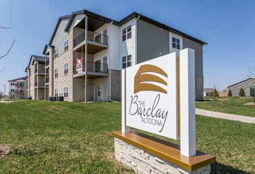 an apartment building with a sign in the grass at The Barclay Apartments, Altoona, IA, 50009