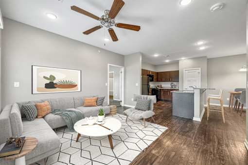 a living room with a couch and a ceiling fan at The Barclay Apartments, Altoona, 50009