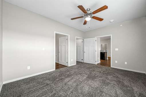 a spacious living room with carpet and a ceiling fan at The Barclay Apartments, Altoona, IA