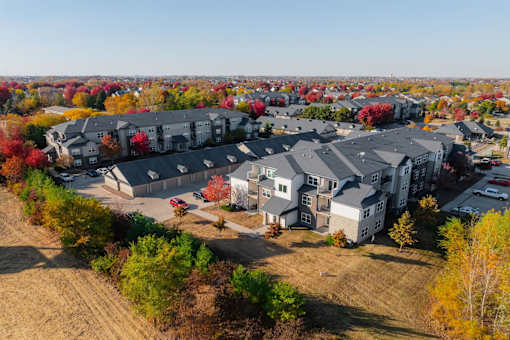 A bird's eye view of a residential area with houses and trees at Stonegate Crossing Apartments, Clive, IOWA
