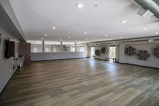 A spacious room with wooden flooring and a white ceiling.at Linc, Des Moines, IA  