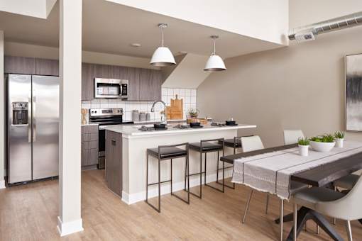 A modern kitchen with a refrigerator, stove, and bar area.at Linc, Iowa, 50309