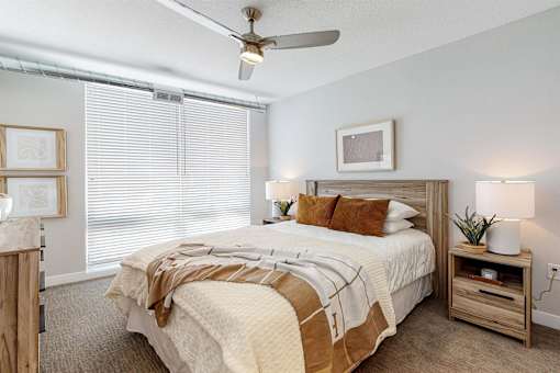 A bedroom with a bed, nightstand, and a ceiling fan.at Linc, Des Moines, IA 50309  