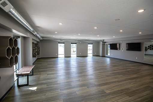A room with wooden floors and a bench.at Linc, Des Moines Iowa   