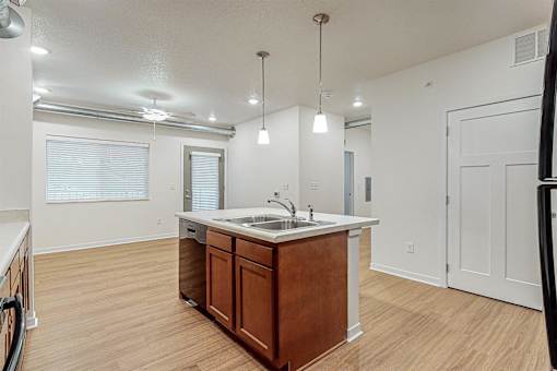 A kitchen with a wooden island and white countertop at Melbourne Apartments, Des Moines