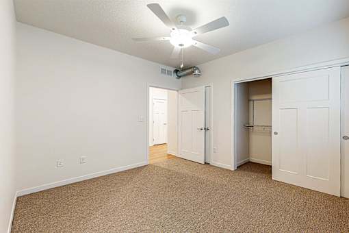 A room with a ceiling fan and carpeted floor at Melbourne Apartments, Des Moines, IA,  50320