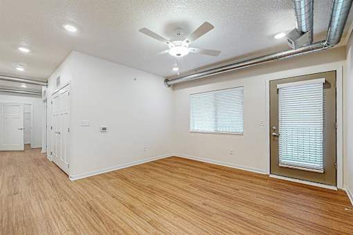 A room with a ceiling fan and wooden flooring at Melbourne Apartments, Des Moines, IA,  50320