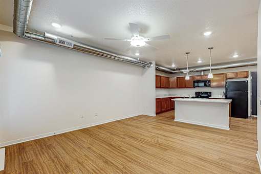 A kitchen area with a white counter and wooden flooring at Melbourne Apartments, IA, 50320