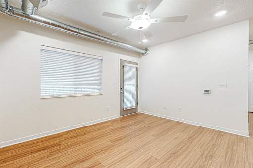 A room with a ceiling fan and a door at Melbourne Apartments, Des Moines, Iowa