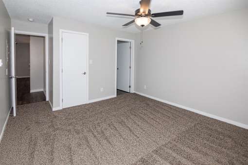 A room with a ceiling fan and carpeted floor at Rosemont Place Apartments, Iowa