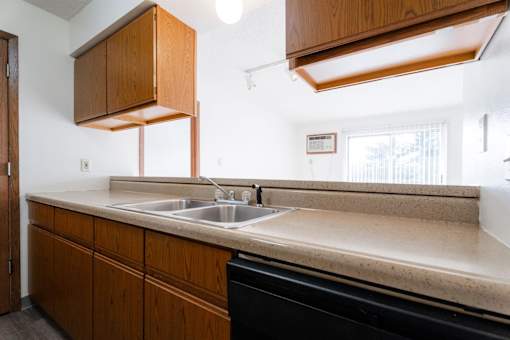 A kitchen with a sink and wooden cabinets at Rosemont Place Apartments, Des Moines, Iowa