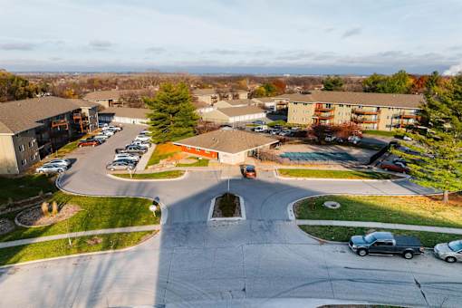 A parking lot with cars and apartment buildings in the background. at Rosemont Place Apartments, Iowa