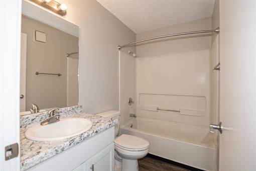 A white bathroom with a sink, toilet, and bathtub. at Rosemont Place Apartments, Des Moines, 50320