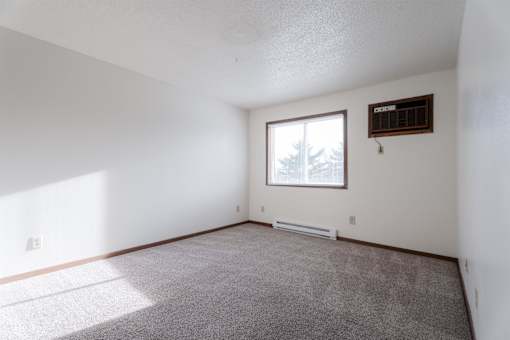 A room with a window and a radiator on the wall at Rosemont Place Apartments, Des Moines