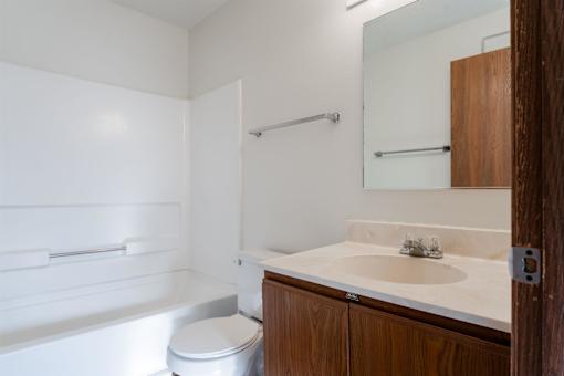 A white bathroom with a toilet, sink and bathtub at Rosemont Place Apartments, Des Moines, IA, 50320
