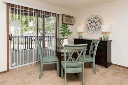 a dining room with a table and chairs and a balcony at Rosemont Place Apartments, Iowa