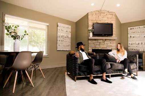 a man and woman sitting on a couch in a living room at Rosemont Place Apartments, Des Moines, IA, 50320